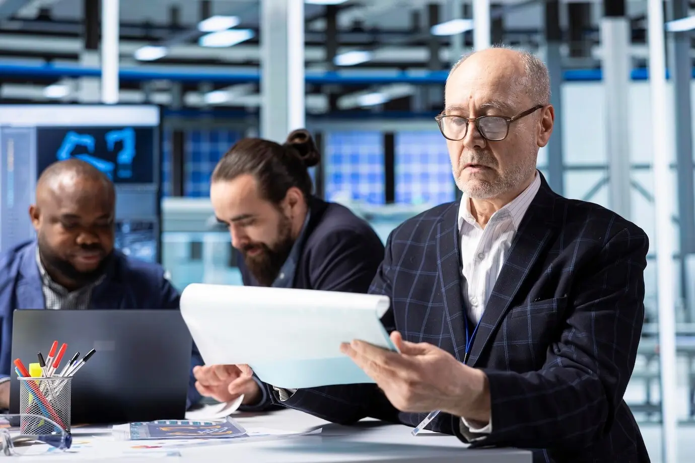 Accionista sénior de una planta industrial revisando documentos y analizando los ingresos.